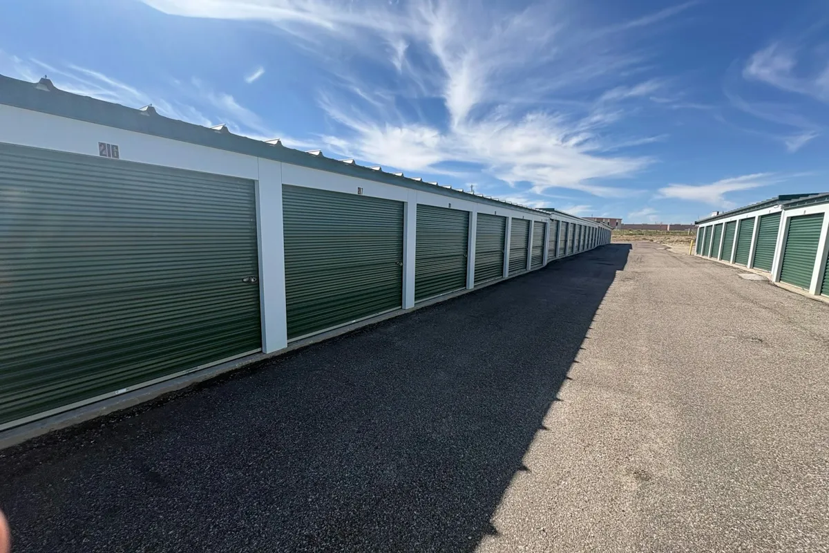 Row of storage units with green roll-up doors